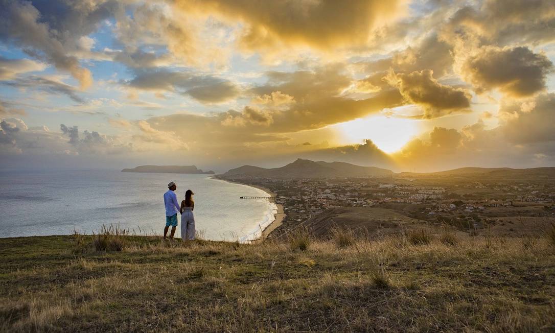 Casal observa o pôr do sol na Ilha de Porto Santo, no arquipélago da Madeira, Portugal Foto: André Carvalho / Turismo da Madeira / Divulgação