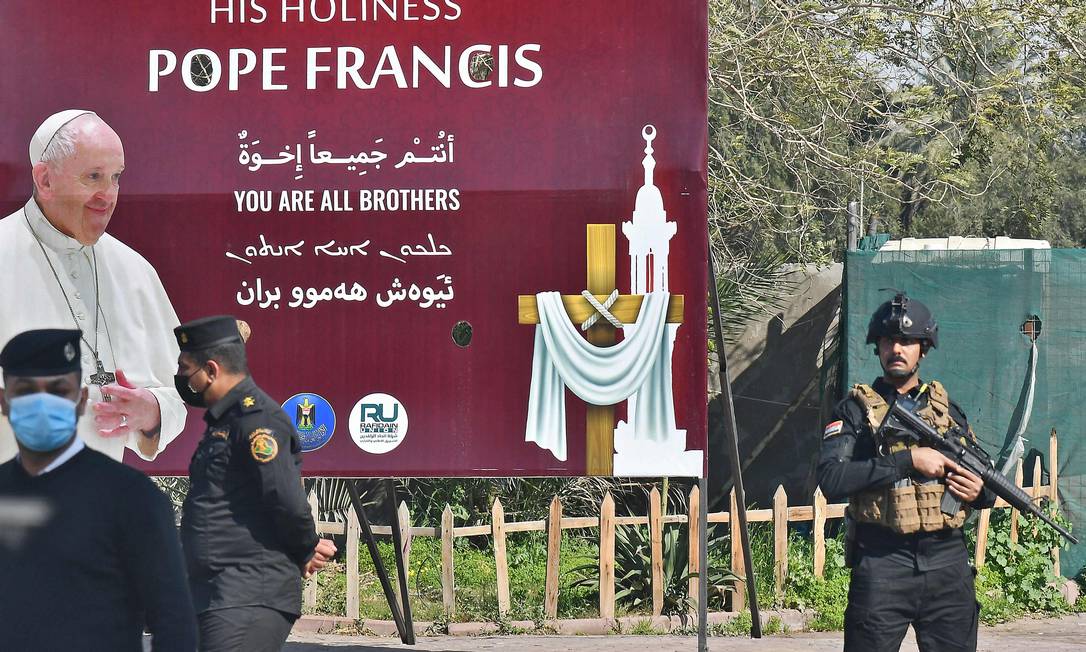 Policiais fazem guarda diante de cartaz de a boas-vindas ao Papa Francisco em Bagdá Foto: VINCENZO PINTO / AFP