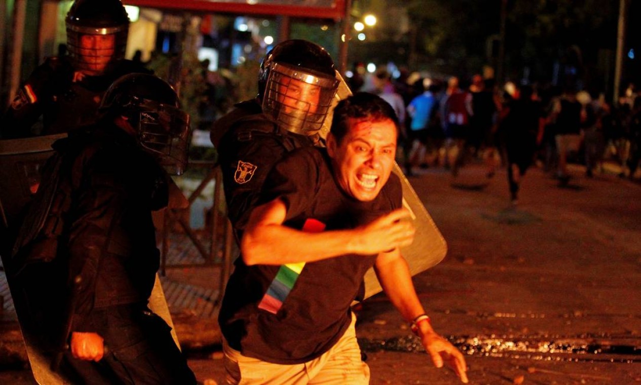 Policiais de choque enfrentam manifestante durante protesto. Uma pessoa morreu e outras 38 ficaram feridas depois de confrontos Foto: CESAR OLMEDO / REUTERS
