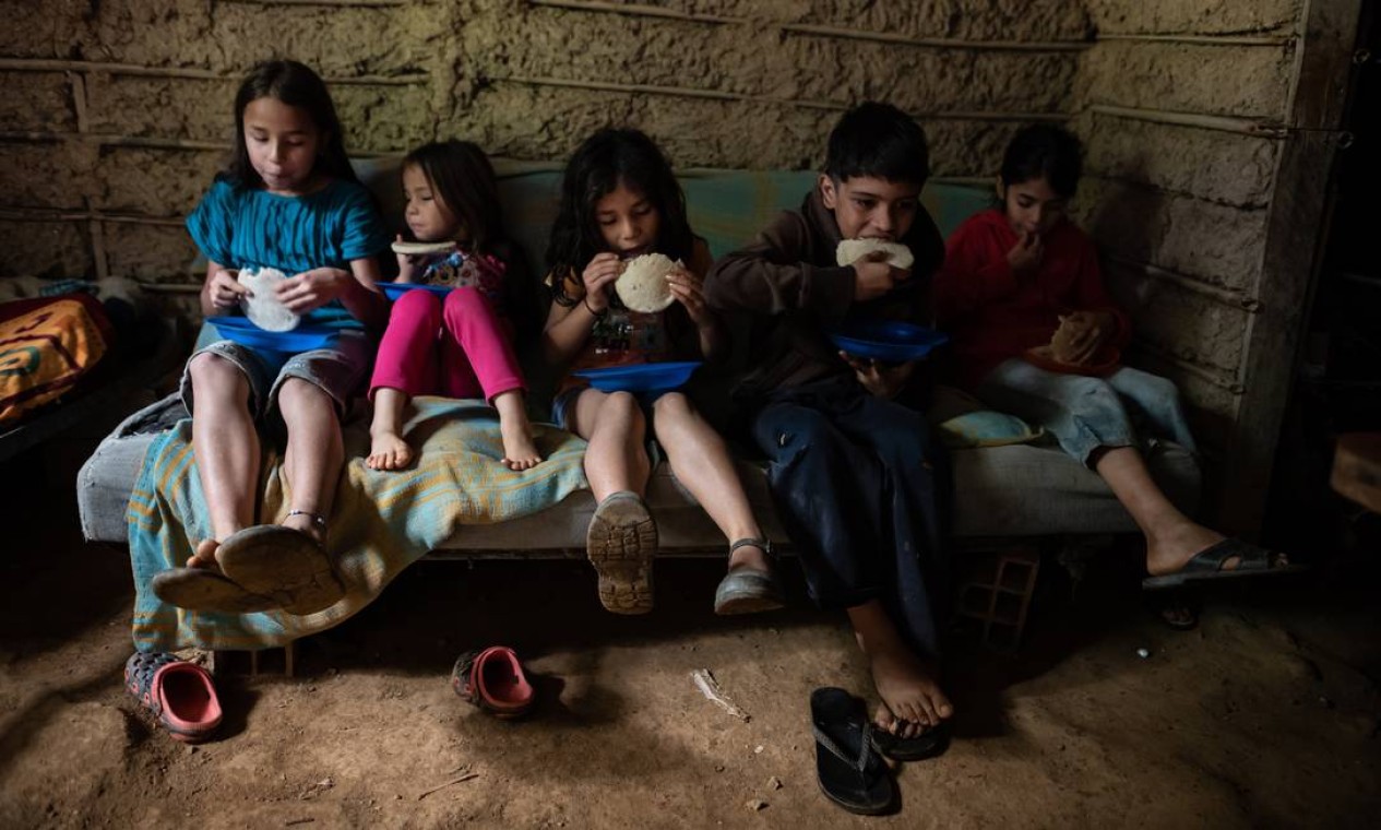 Os quatro filhos de Johanna Guzman, 25 anos, comem com o irmão mais moço da mãe (07.12.2020). Contraceptivos não são acessíveis para a maioria das venezuelanas, o que as leva a gravidezes indesejadas em um momento em que mal conseguem alimentar os filhos que já têm Foto: MERIDITH KOHUT / NYT