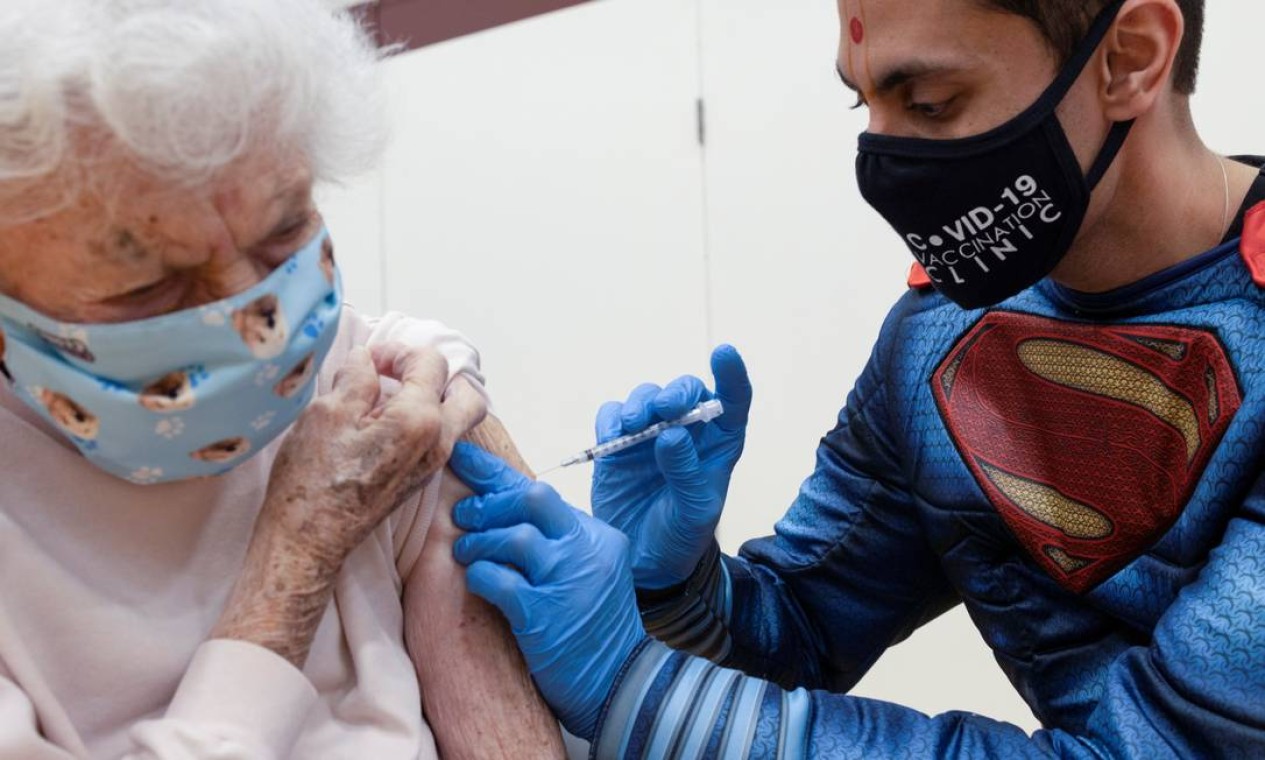 O Dr. Mayank Amin administra a vacina contra doença o coronavírus da Pfizer-BioNTech em Helen Pepe, 94 anos, em uma clínica administrada pela Skippack Pharmacy em Collegeville, Pensilvânia, EUA. Mais de 54% da população do pais já tomou, pelo menos, a primeira dose da vacina Foto: HANNAH BEIER / REUTERS