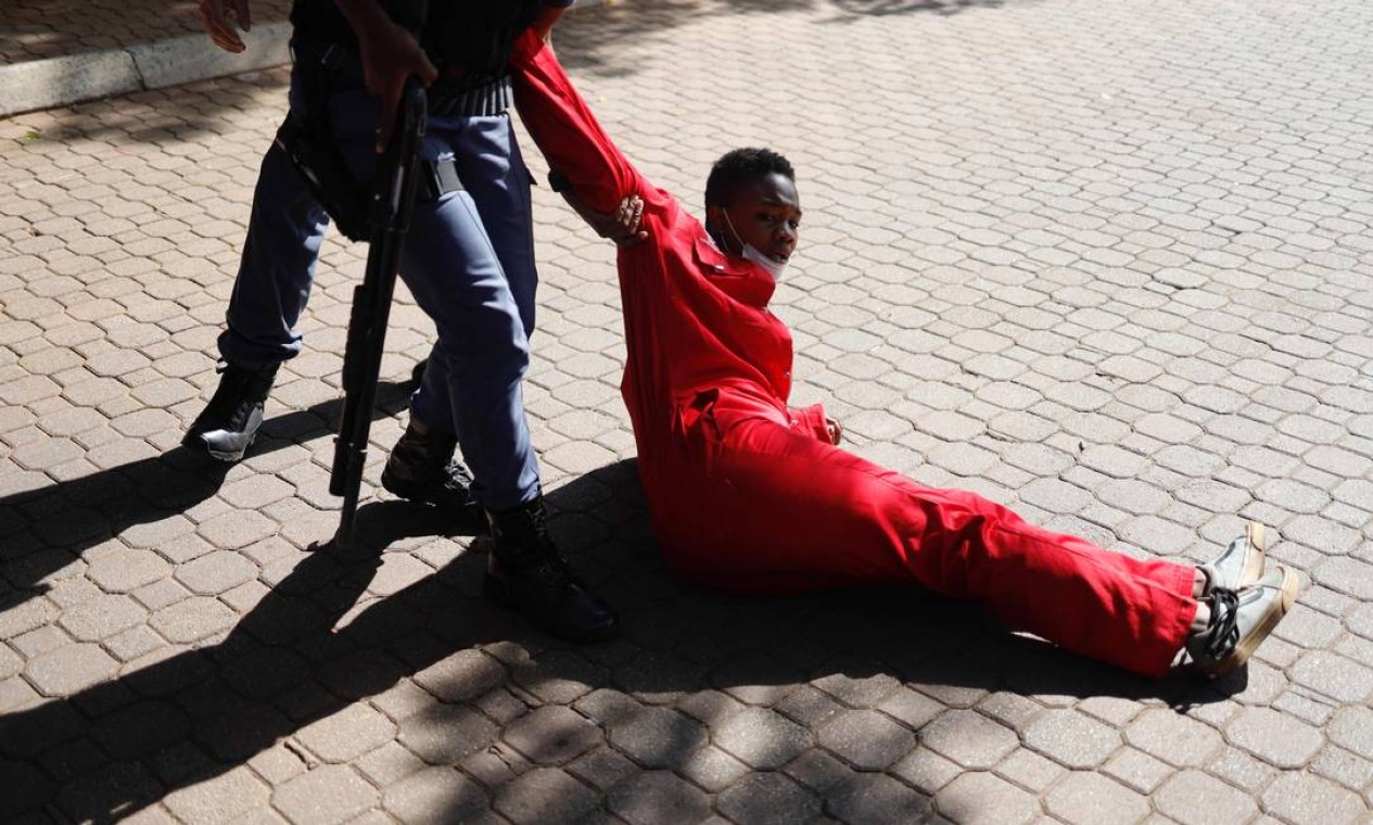 Membro do Serviço de Polícia da África do Sul (SAPS) arrasta um estudante membro do Economic Freedom Fighters (EFF) durante um protesto em Braamfontein, Joanesburgo. Uma pessoa foi morta a tiros depois que a polícia sul-africana se mobilizou para dispersar estudantes que protestavam contra a recusa de uma importante universidade de Joanesburgo em registrar os atrasados com as mensalidades. A polícia usou balas de borracha para dispersar grupo de estudantes que bloqueava estradas com entulho e interrompia o tráfego no centro em torno do campus de Wits, na capital do país Foto: MICHELE SPATARI / AFP