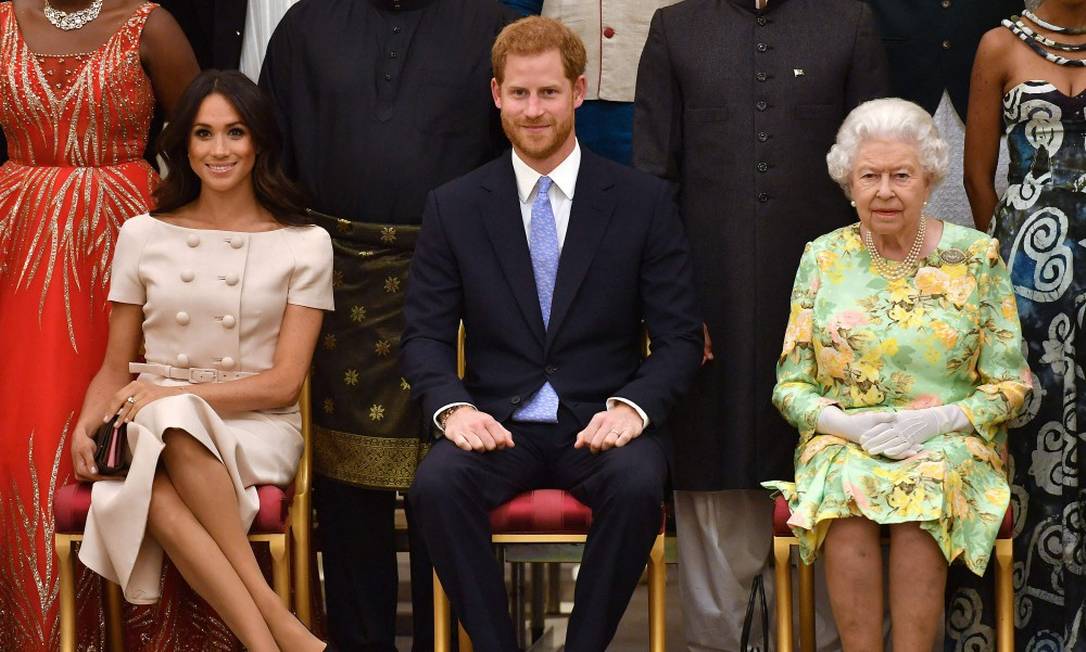 Meghan, o príncipe Harry e a rainha Elizabeth II durante evento no Palácio de Buckingham em 2018 Foto: JOHN STILLWELL / AFP / 26-6-2018