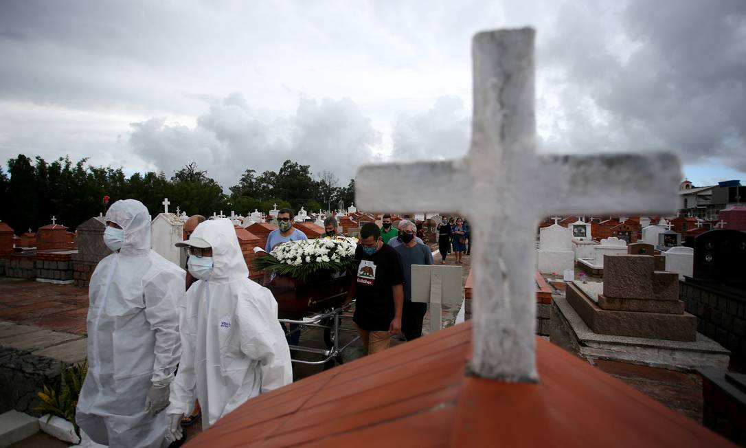 Parentes e amigos carregam o caixão durante o enterro de Paulo Carletti, 76, falecido por coronavírus, no cemitério de Belém Novo, em Porto Alegre, Rio Grande do Sul Foto: Diego Vara / Reuters - 05/03/2021