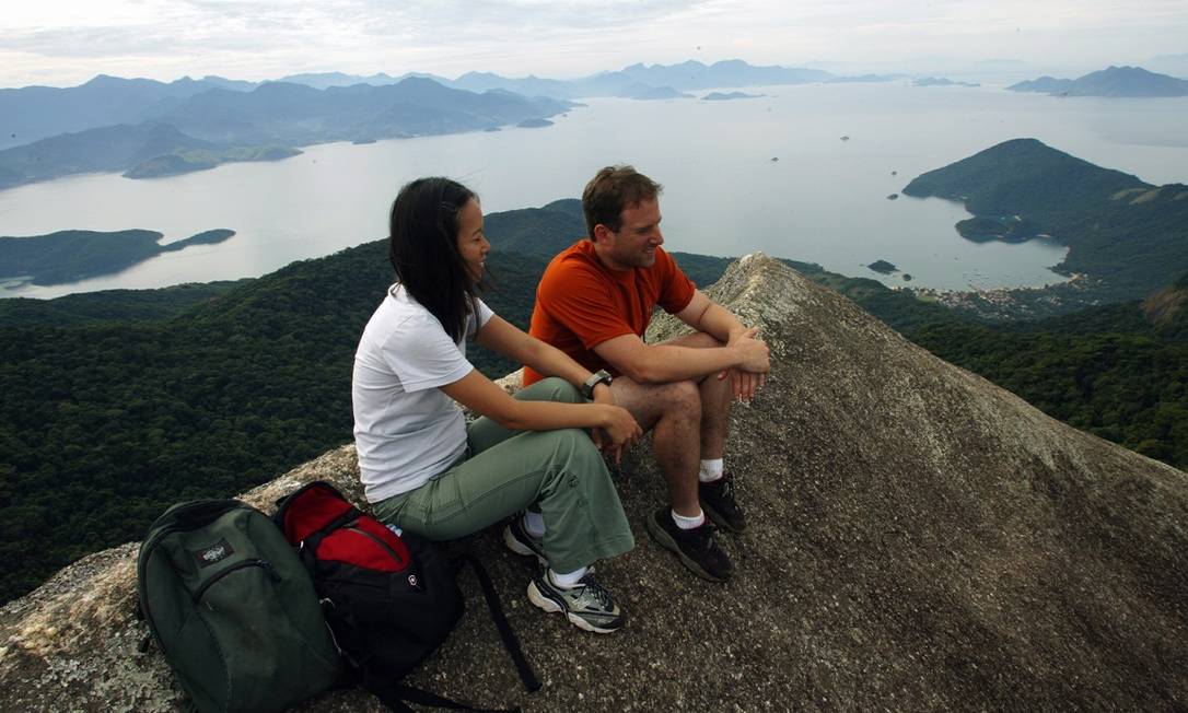 Turistas no cume do Pico do Papagaio, com a enseada do Abraão ao fundo, na Ilha Grande Foto: André Coelho / Arquivo / Agência O Globo