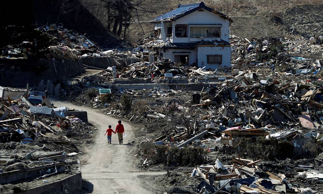 Pessoas caminham por destroços do tsunami e do terremoto em Miyako, no dia 5 de abril de 2011 Foto: Toru Hanai / REUTERS