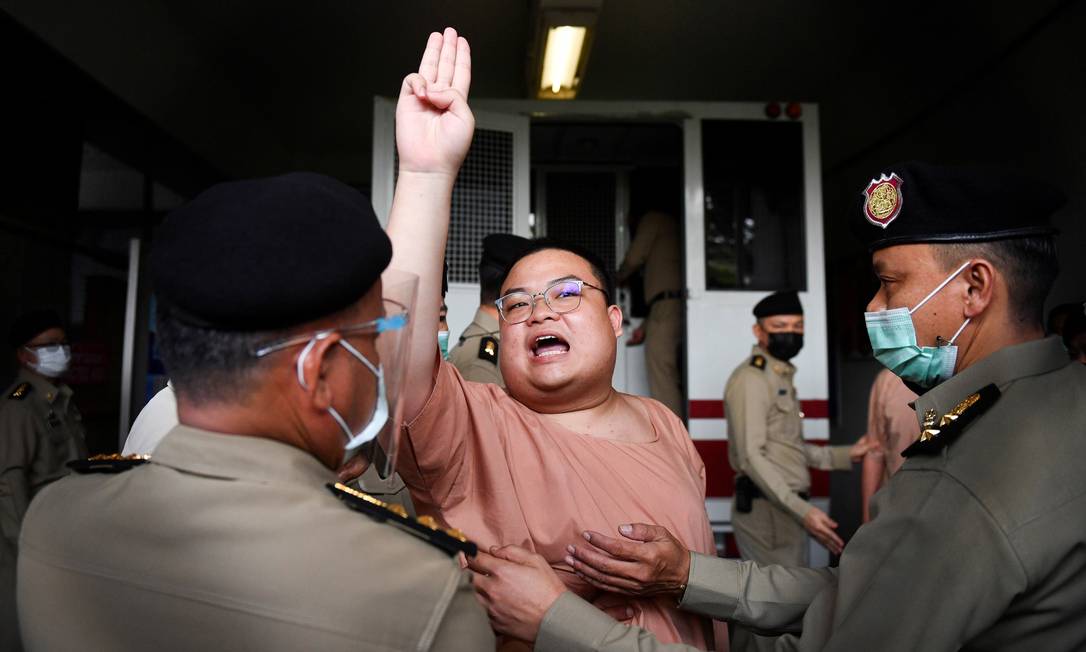 Parit "Penguin" Chiwarak faz a saudação dos três dedos ao chegar ao tribunal criminal para enfrentar acusações de lesa-majestade em Bangkok, Tailândia Foto: CHALINEE THIRASUPA / REUTERS/15-03-2021