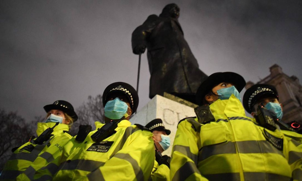 Policiais formam um cordão ao redor de uma estátua do ex-primeiro-ministro Winston Churchill, na Parliament Square, no centro de Londres. A capital britânica viveu fim de semana de protestos pela morte de Sarah Everard, que ficou desaparecida por uma semana até ser encontrada já morta Foto: DANIEL LEAL-OLIVAS / AFP