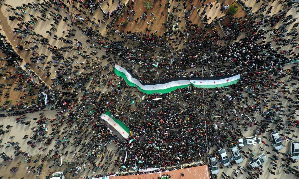 Imagem aérea mostra sírios na cidade Idlib, reduto da resistência ao governo de Bashar al-Assad, em manifestação pelos 10 anos de protestos que de desencadearam a devastadora guerra civil no país Foto: OMAR HAJ KADOUR / AFP