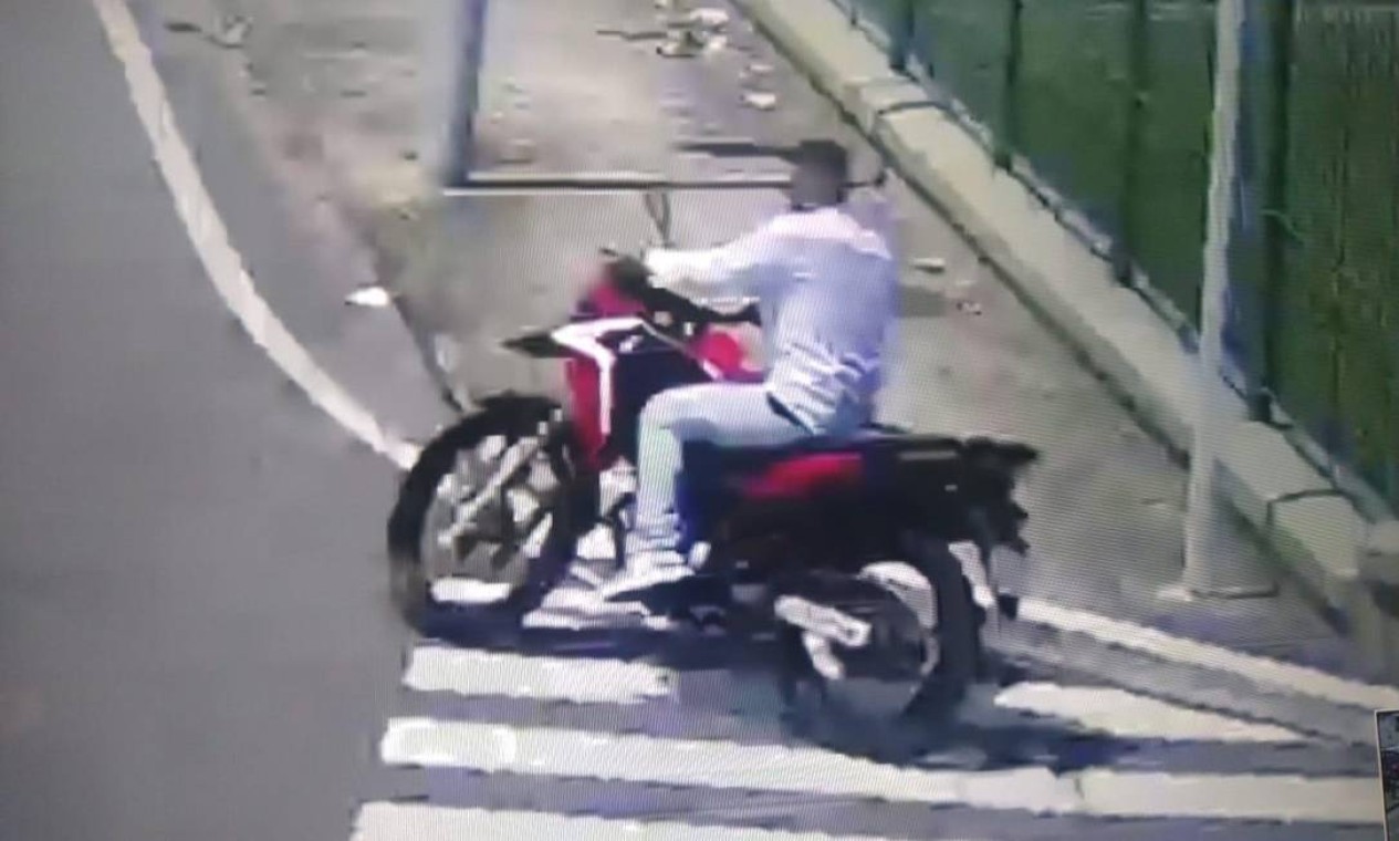 Um dos bandidos foge em uma motocicleta vermelha, como flagrou as câmeras de segurança do estacionamento Foto: Reprodução