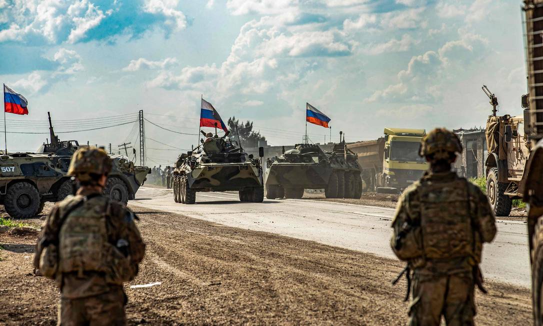 Militares russos em rota na província síria de Hasakah, em 5 de maio de 2020. Á sua frente, um grupamento de militares dos EUA Foto: DELIL SOULEIMAN / AFP