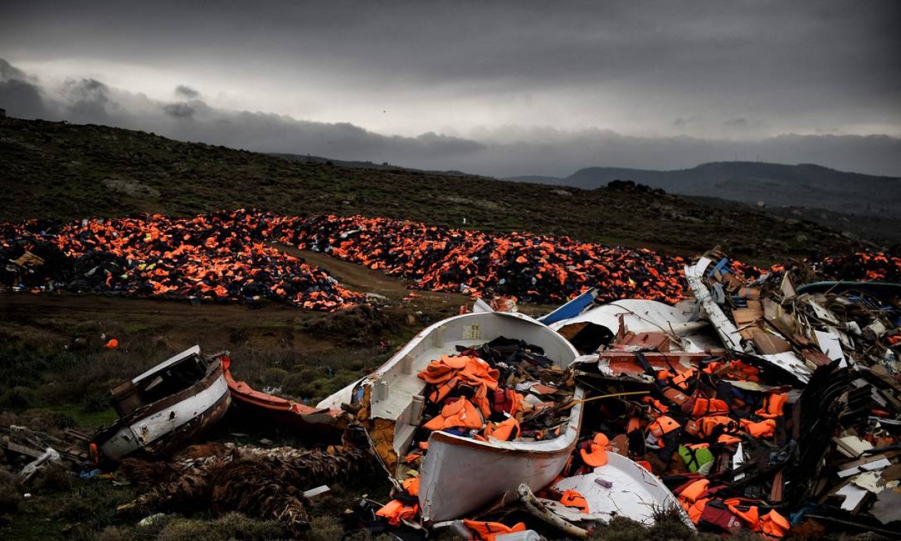 Destroços de barcos naufragados e milhares de coletes salva-vidas usados por refugiados e migrantes durante sua jornada pelo mar Egeu estão em um lixão em Mithimna, Grécia Foto: ARIS MESSINIS / AFP