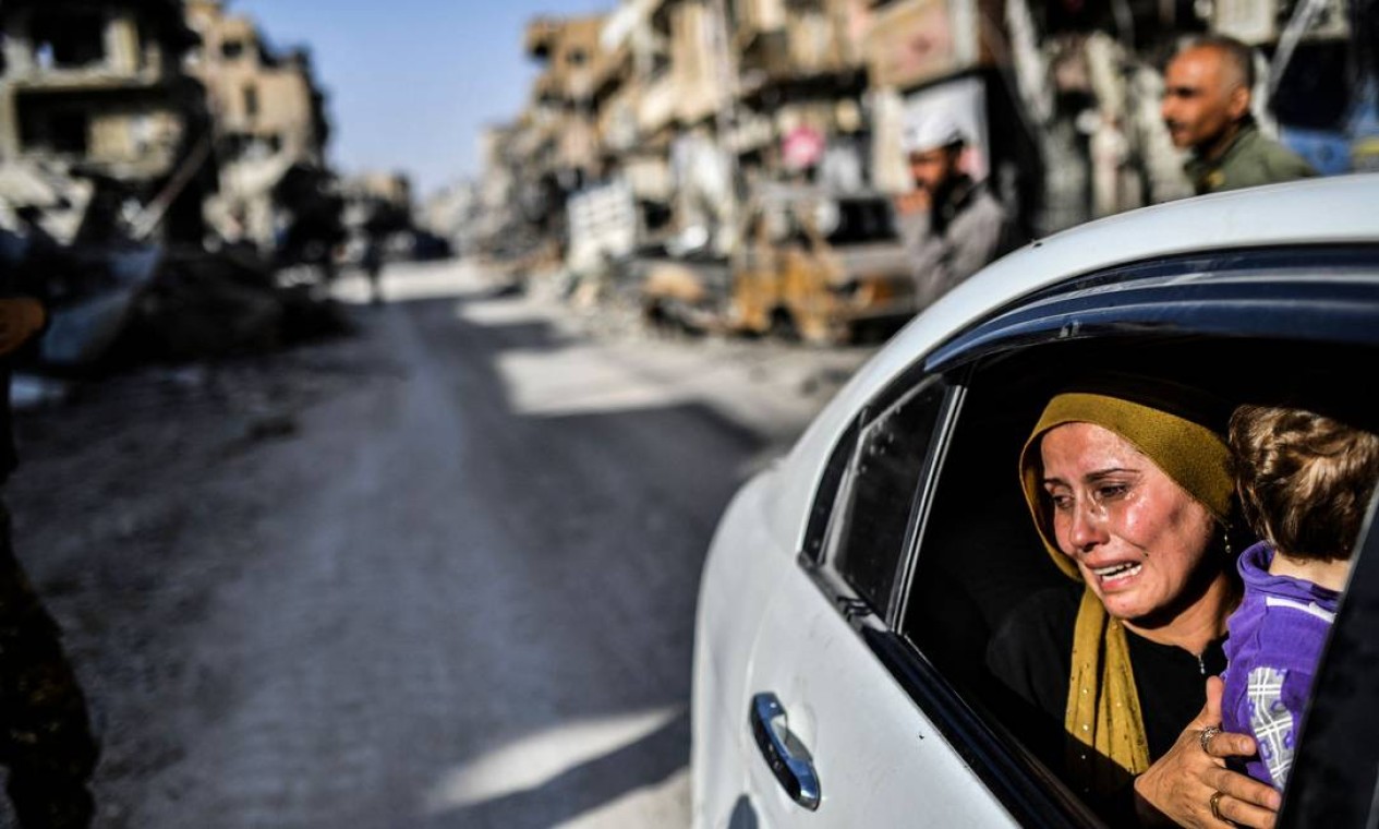Mulher chora ao olhar para sua casa em Raqa, depois que uma força liderada por curdos expulsou o grupo do Estado Islâmico da cidade do norte da Síria Foto: BULENT KILIC / AFP - 20/10/2017
