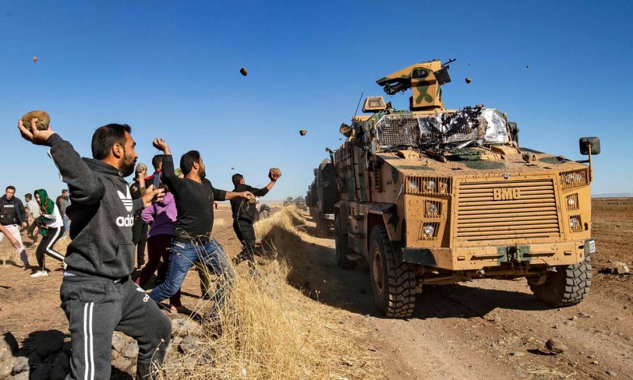 Curdos jogam pedras em um veículo militar turco, durante uma patrulha conjunta turco-russa perto da cidade de Al-Muabbadah, na parte nordeste de Hassakah, na fronteira da Síria com a Turquia Foto: DELIL SOULEIMAN / AFP - 08/11/2019