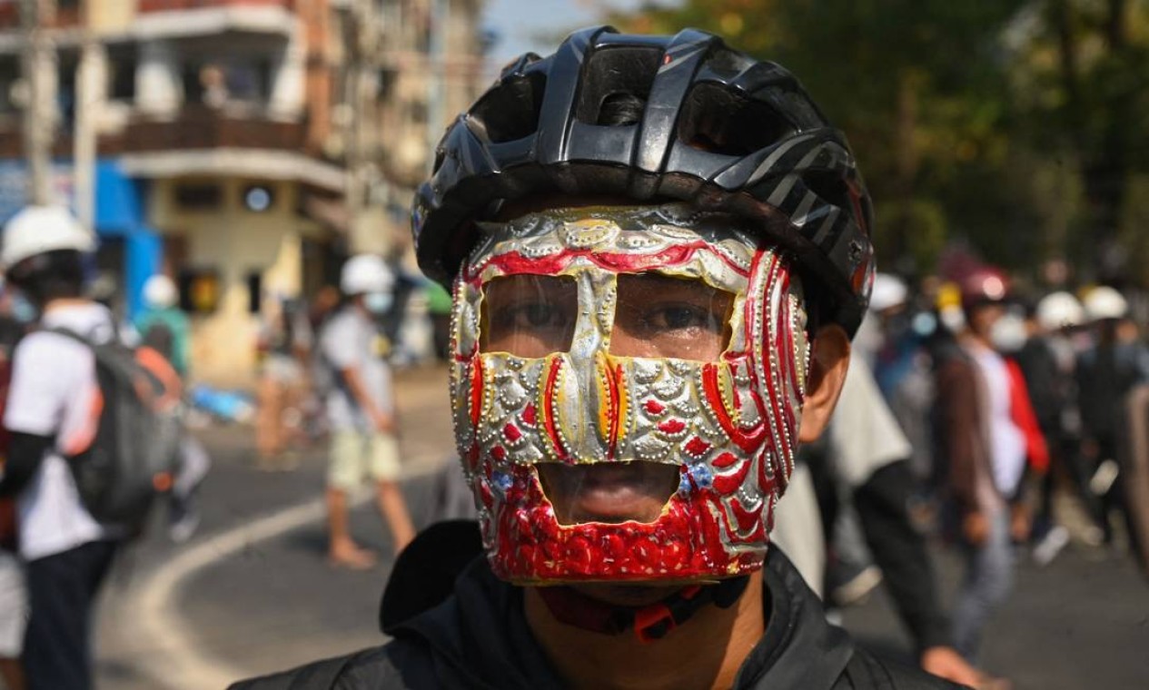 Capacete de ciclismo e máscara improvisada Foto: STR / AFP