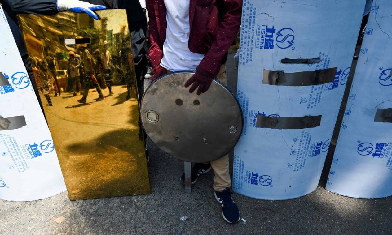 Manifestantes exibem escudos improvisados usados em protestos em Yangon Foto: STR / AFP