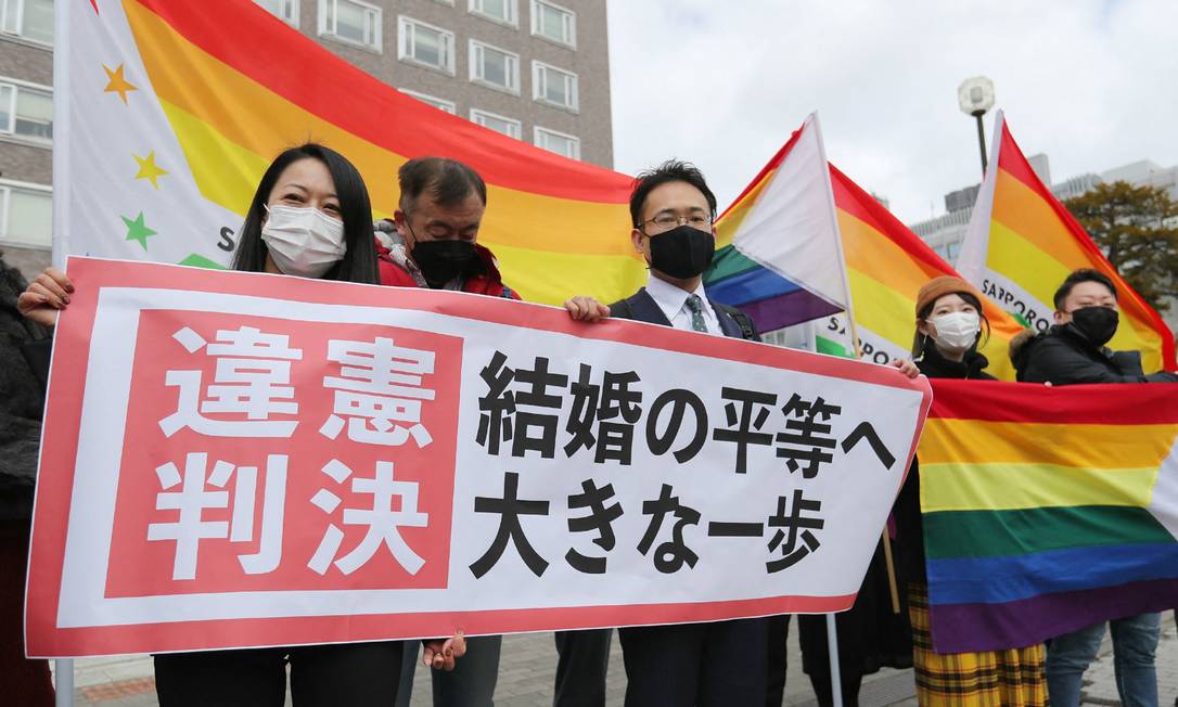 Apoiadores seguram a bandeira do arco-írus em frente ao Tribunal Distrital de Sapporo, prefeitura de Hokkaido em 17 de março de 2021 Foto: STR / AFP