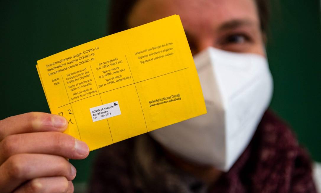 Mulher mostra seu certificado de vacinação após ser imunizada na cidade de Halle, no Leste da Alemanha Foto: JENS SCHLUETER / AFP / 12-2-21