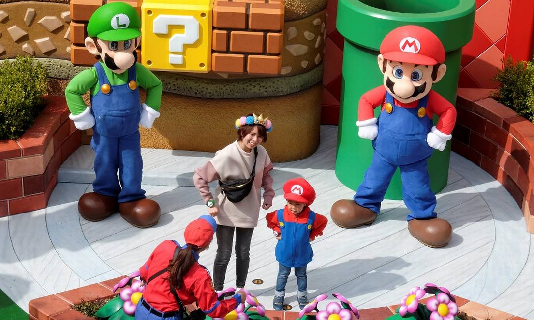 Mario e Luigi posam ao lado duas visiantes da Super Nintendo World, nova área temática do parque Universal Studios Japan, em Osaka Foto: IRENE WANG / REUTERS
