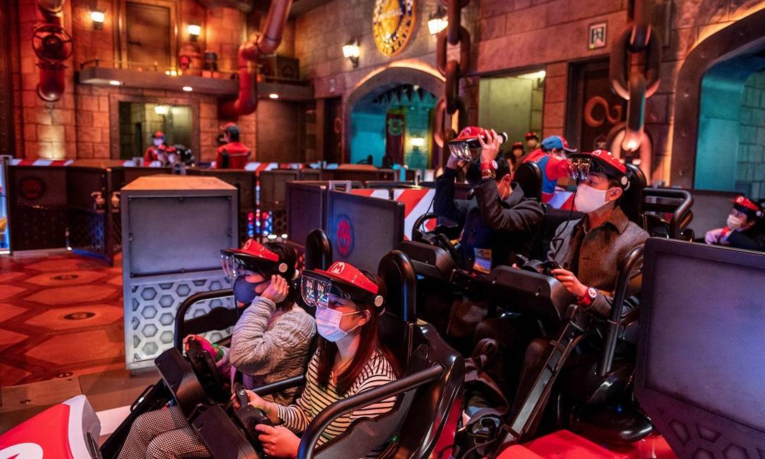 Visitantes a bordo de um dos carrinhos da atração baseada no jogo 'Mario Kart' na área Super Nintendo World, do parque Universal Studios Japan, em Osaka Foto: PHILIP FONG / AFP