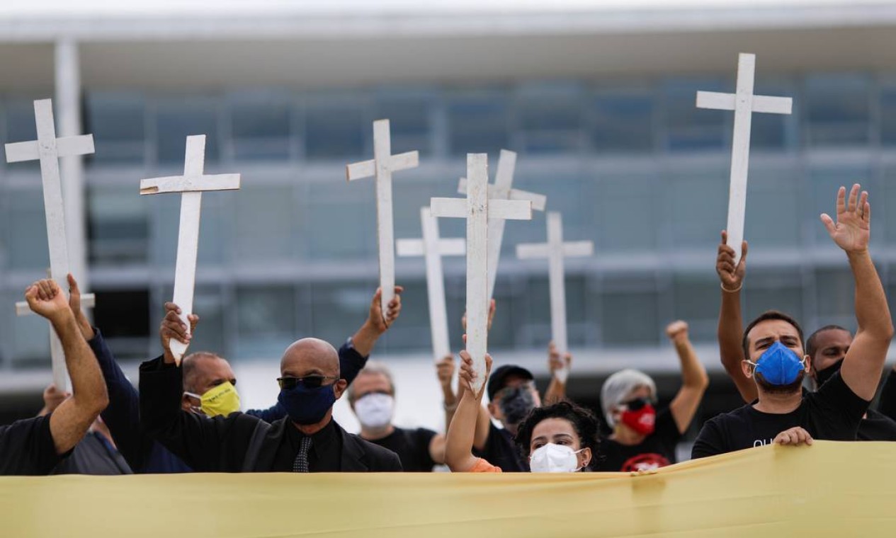 Os manifestantes também levaram cruzes para marcar os mortos pela pandemia de Covid-19. Foto: UESLEI MARCELINO / REUTERS