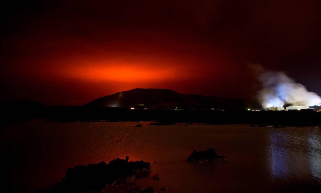 O brilho vermelho do magma fluindo do vulcão em erupção Fagradalsfjall, atrás da Lagoa Azul, cerca de 45 km a oeste da capital da Islândia, Reykjavik Foto: HALLDOR KOLBEINS / AFP