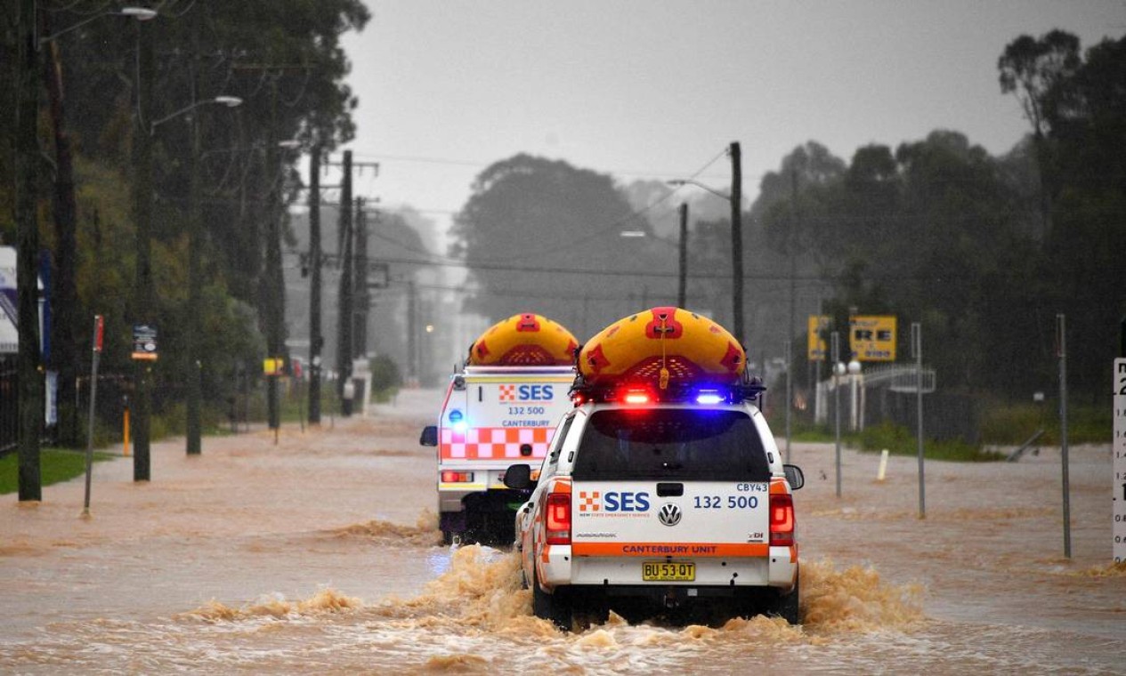 Veículos do Serviço de Emergência se aproximam de áreas residenciais inundadas no oeste de Sydney. Chuvas torrenciais acima da média causaram evacuações em massa na maior cidade da Austrália Foto: SAEED KHAN / AFP
