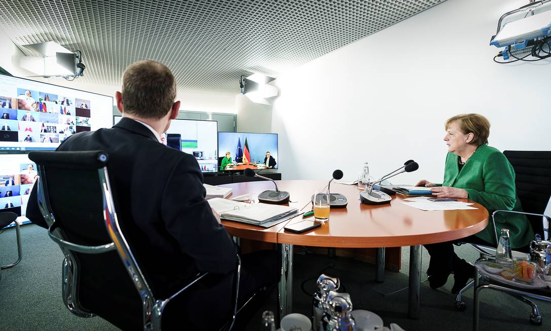 A chanceler alemã Angela Merkel e o prefeito de Berlim Michael Mueller participam de uma videoconferência com líderes estaduais na Chancelaria em Berlim Foto: JESCO DENZEL / via REUTERS