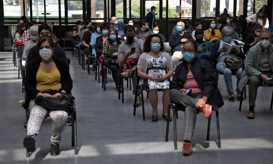 Chilenos esperam sua vez de receber a vacina em centro de imunização em Santiago Foto: CLAUDIO REYES / AFP/16-3-21