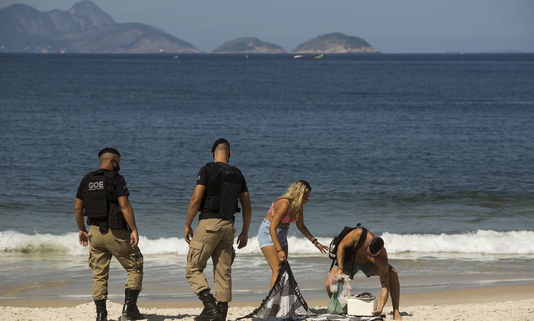 Guardas municipais retiram pessoas da praia de Copacabana Foto: Guito Moreto / Agência O Globo