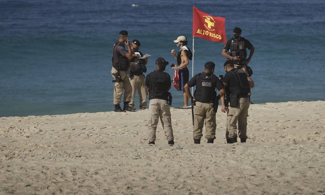 Equipe da Guarda Municipal multa banhista que estava sem máscara e ocupava a areia da praia de Ipanema no último domingo Foto: Márcia Foletto