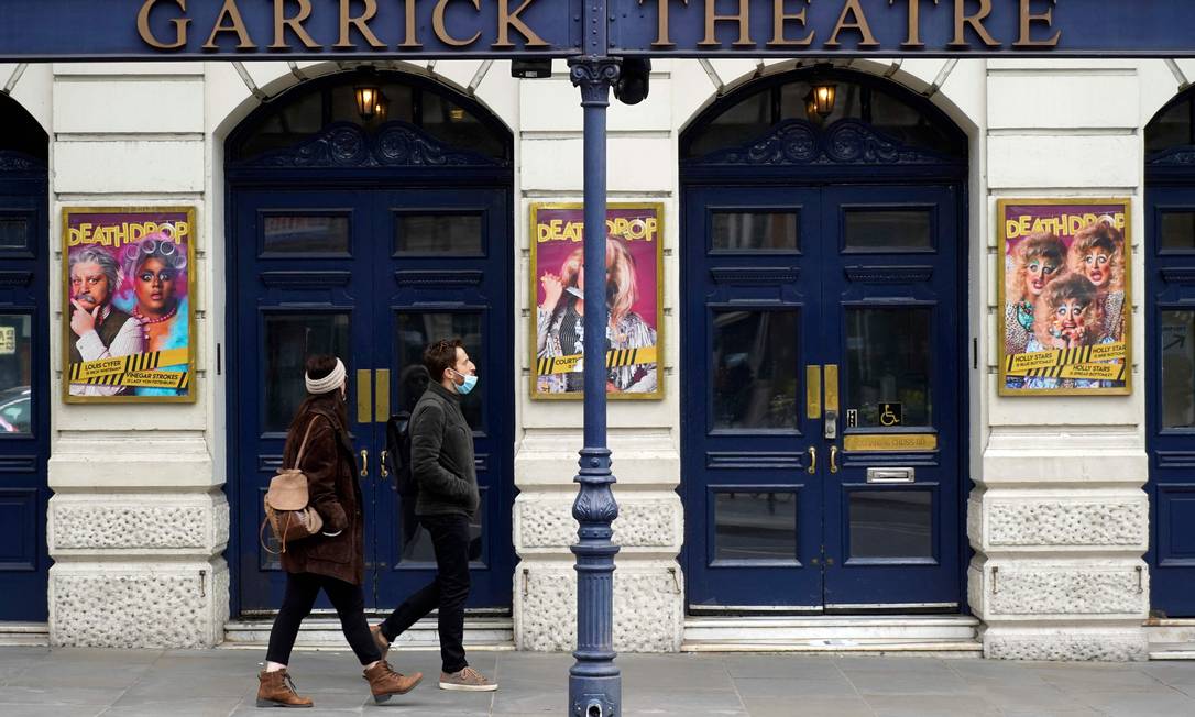 Pedestres passam por cinema fechado em Londres; segundo o cronograma de desconfinamento, casas de espetáculo só reabrem em maio, com lotação limitada Foto: NIKLAS HALLE'N / AFP/21-03-2021