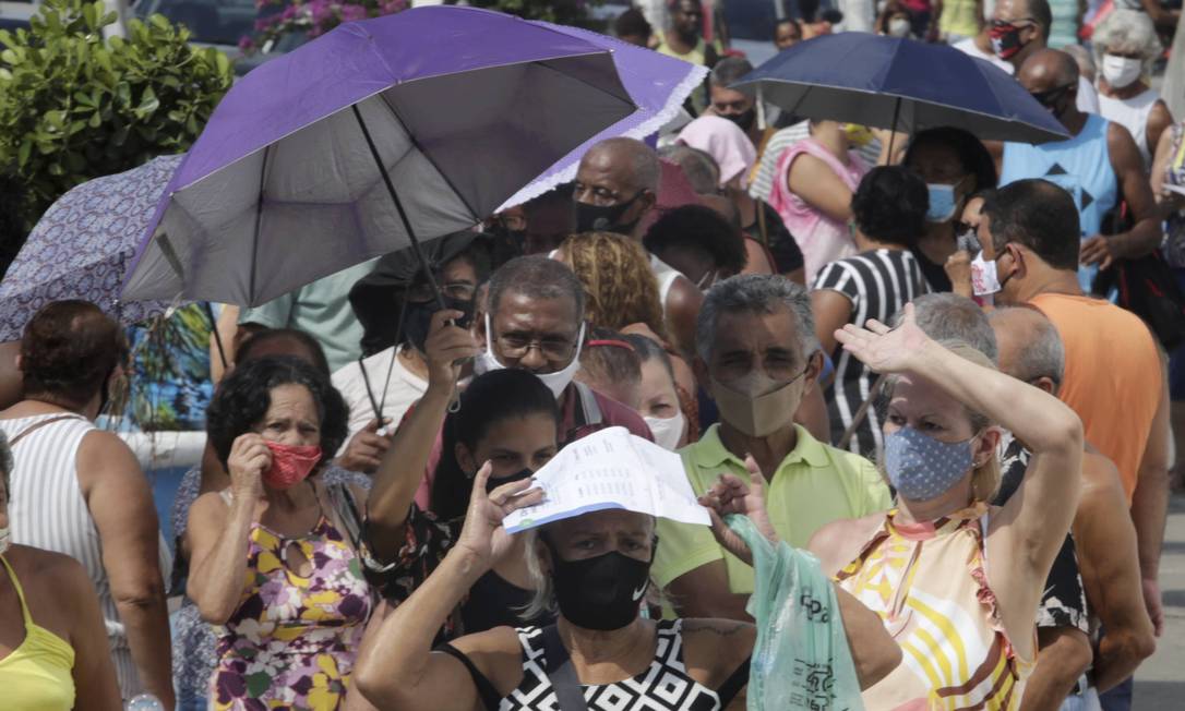 The idodos protect themselves from the sun while they face long waiting times to be vaccinated against Covid-19 Photo: Domingos Peixoto / Agência O Globo - 03/29/2021