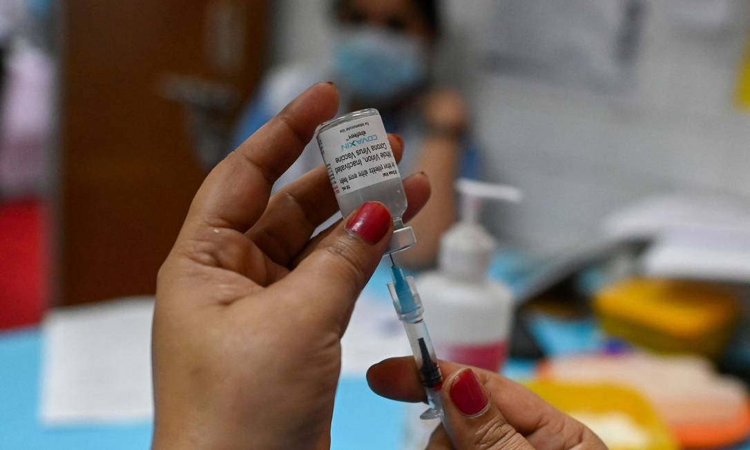 Profissional da saúde prepara dose de vacina contra a Covid-19 Covaxin Foto: SAJJAD HUSSAIN / AFP