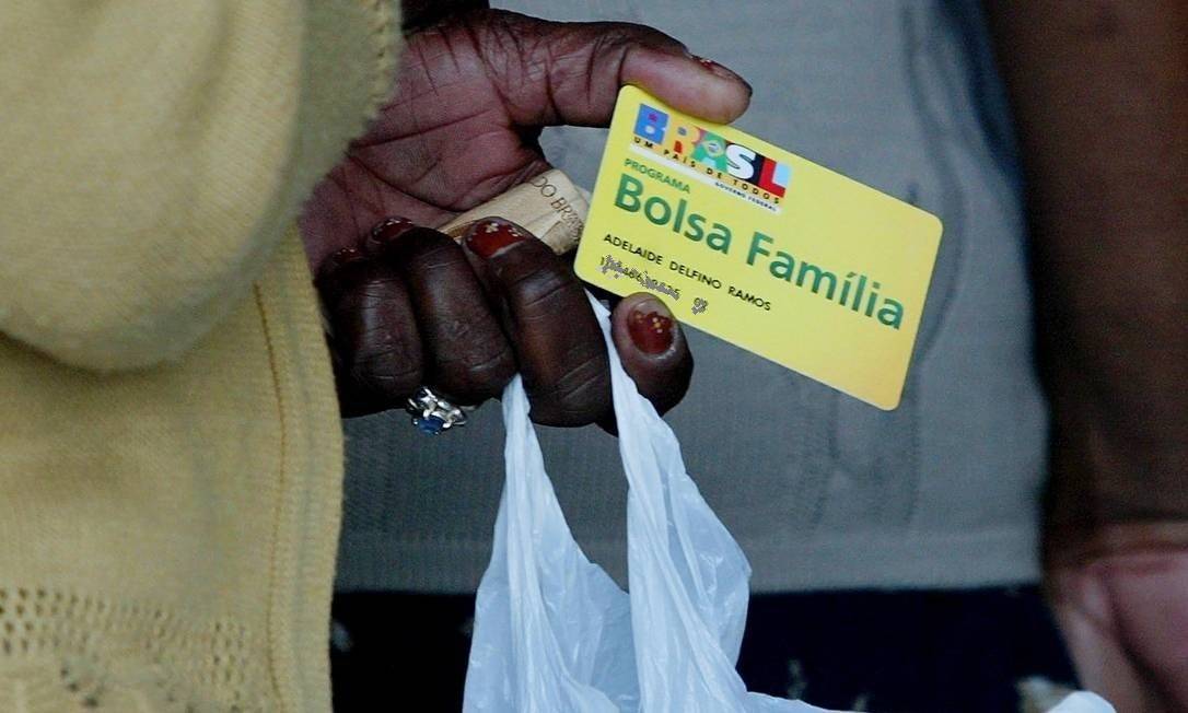 Beneficiária segura cartão do Bolsa Família Foto: Michel Filho / Agência O Globo