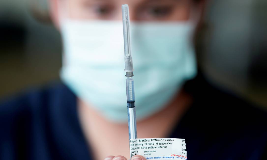 Profissional de saúde prepara dose de vacina da Pfizer, na Austrália Foto: SANDRA SANDERS / REUTERS
