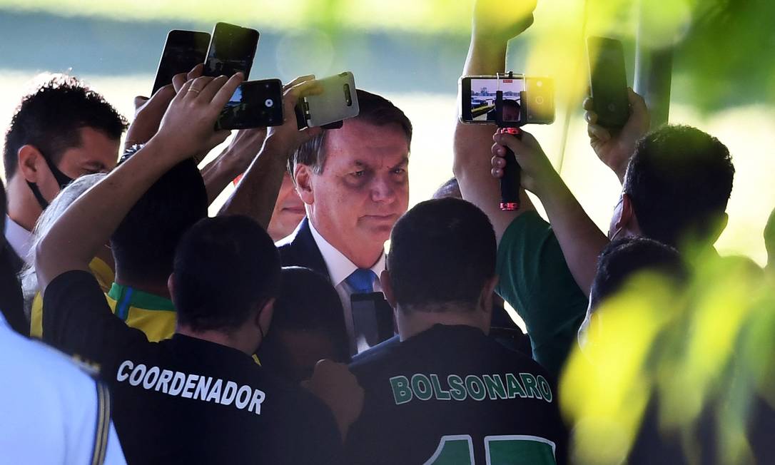 O presidente brasileiro Jair Bolsonaro, sem usar máscara de proteção, se aglomera para falar com apoiadores ao deixar o Palácio da Alvorada, em Brasília Foto: Evaristo Sá / AFP - 31/03/2021