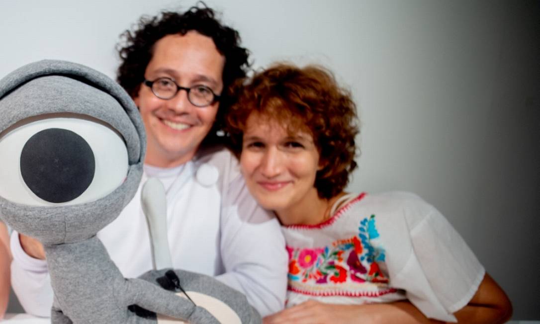 Alexandre Guimarães e Letícia Medella com o boneco Optiké Foto: Divulgação/Eduardo da Matta