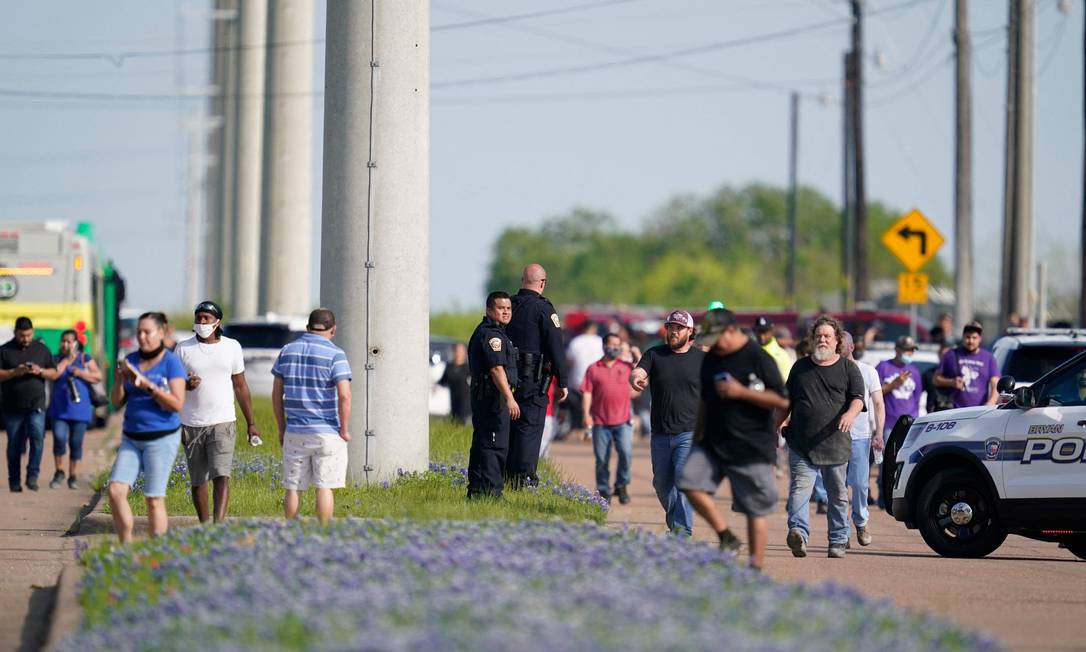 Equipes de polícia de Bryan, no Texas, orientam funcionários para fora da fábrica onde atirador matou uma pessoa Foto: SAM CRAFT / AFP