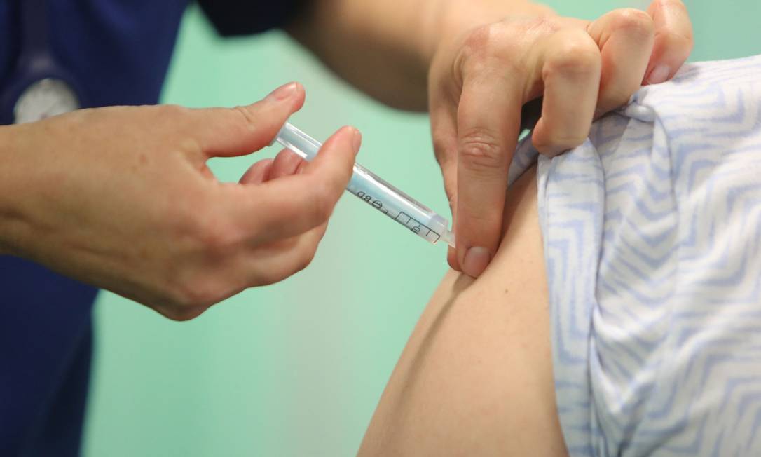 Profissional de saúde administra uma injeção de vacina contra a Covid-19 Foto: GEOFF CADDICK / AFP