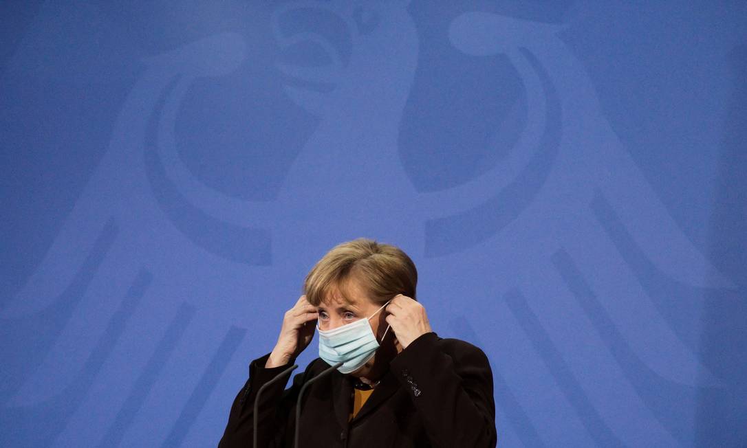 Chanceler alemã Angela Merkel coloca máscara durante entrevista coletiva no dia 30 de março Foto: POOL / REUTERS