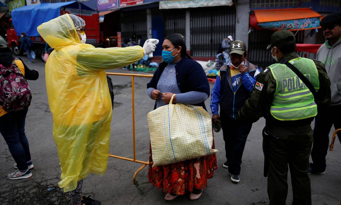 Profissional de saúde checa a temperatura da população boliviana em La Paz, capital do país Foto: DAVID MERCADO / Reuters
