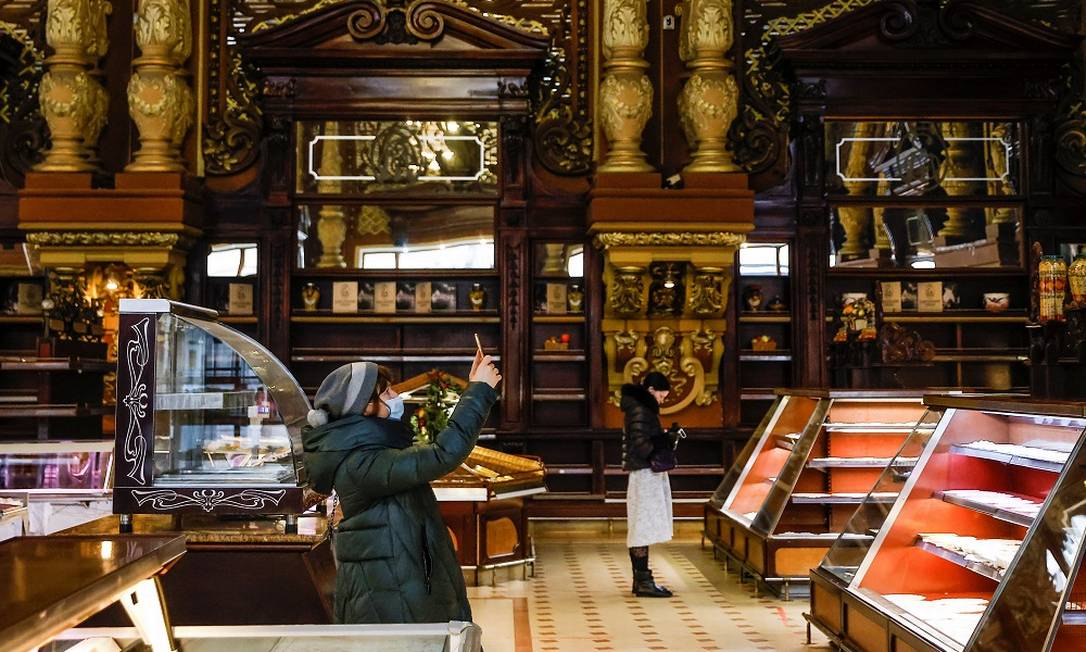 Cliente fotografa o interior da Yeliseyevsky, onde já se vê prateleiras e mostradores vazios Foto: MAXIM SHEMETOV / REUTERS
