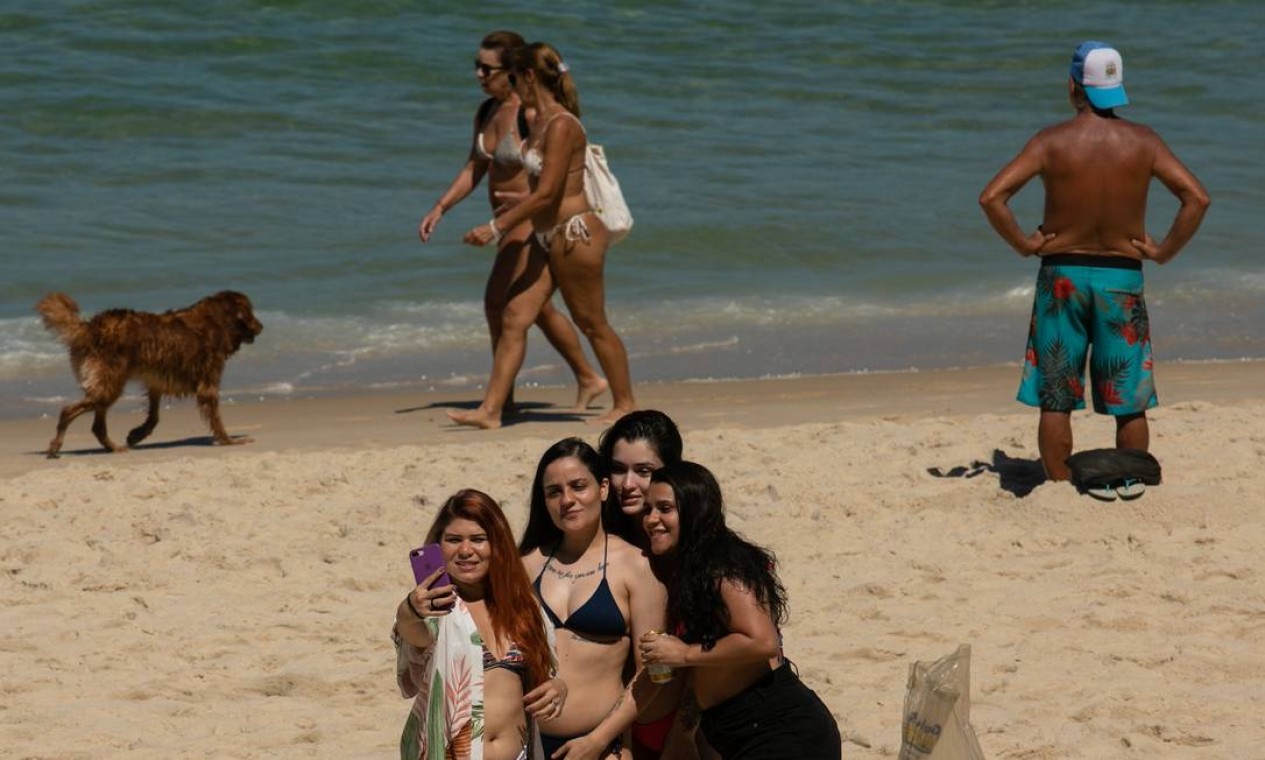 Sem máscara, jovens posam para foto na praia do Arpoador Foto: Brenno Carvalho / Agência O Globo