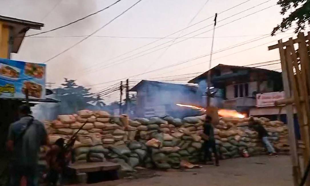 Imagens mostram civis lançando fogos de artifício em direção a militares e protegidos por uma barricada na cidade de Bago, onde mais de 80 pessoas morreram após ataque da Junta Foto: HANDOUT / AFP