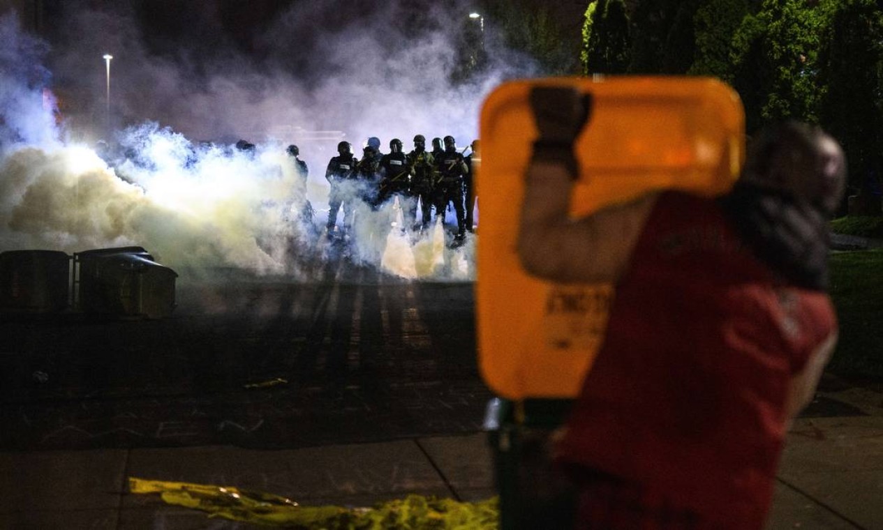 Policiais lançam gás lacrimogêneo para dispersar os manifestantes do lado de fora da sede da polícia do Brooklyn Center Foto: Stephen Maturen / AFP