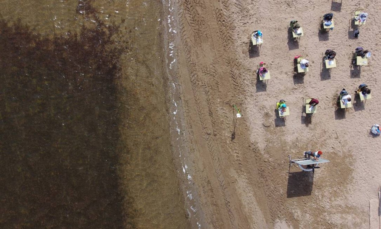 Imagem aérea mostra alunos da escola durante aula à beira-mar Foto: NACHO DOCE / REUTERS