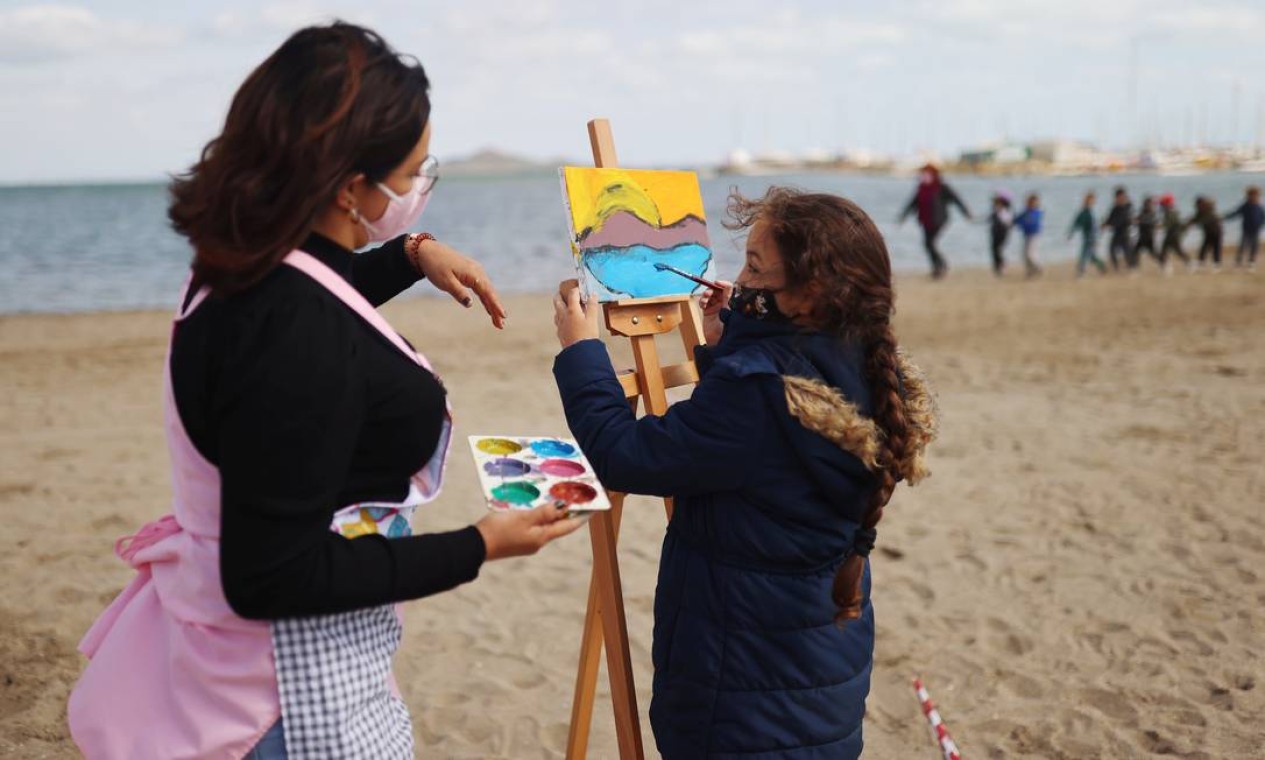 Professora orienta aluna durante ao de arte em praia no sul da Espanha Foto: NACHO DOCE / REUTERS