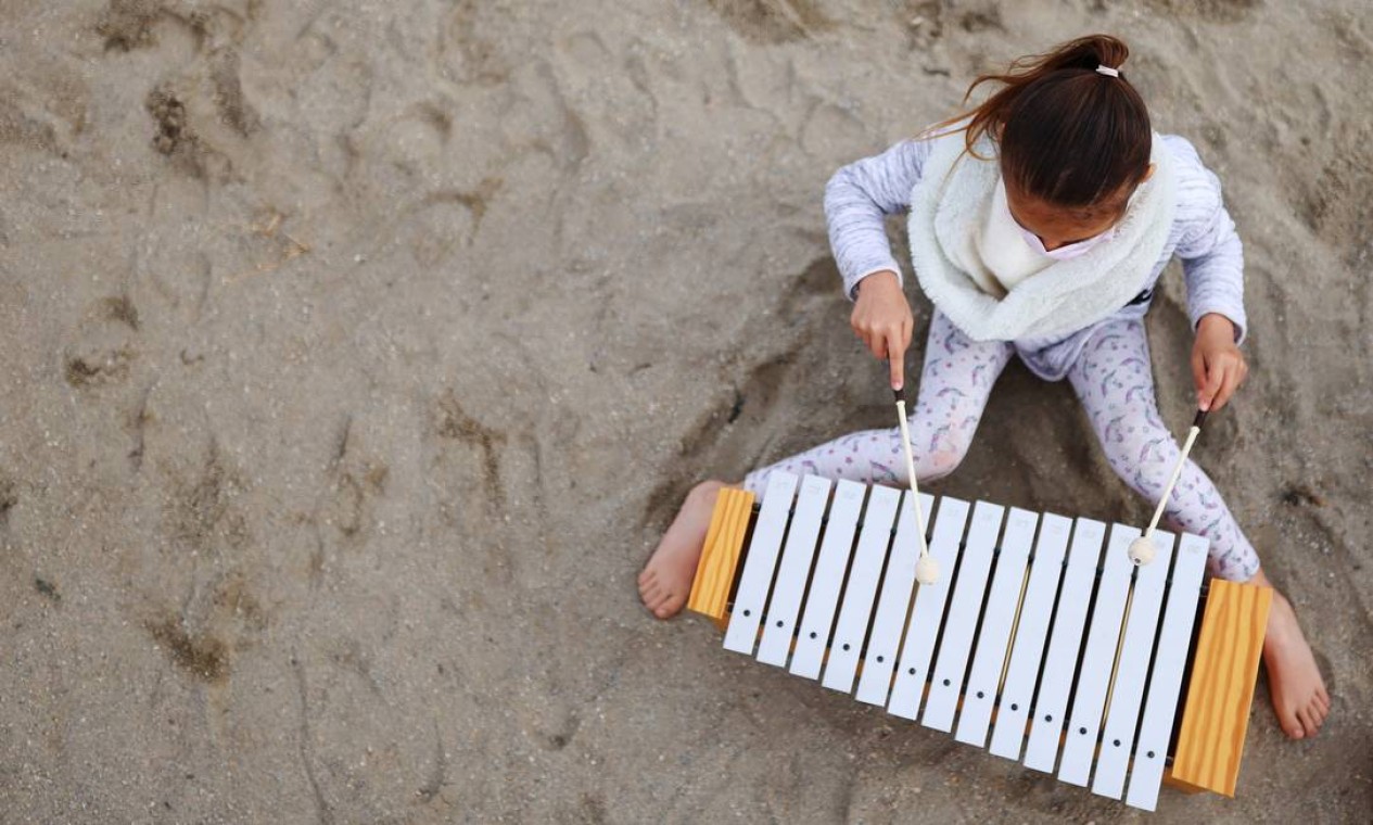 Uma aluna toca xilofone durante uma aula do projeto Foto: NACHO DOCE / REUTERS