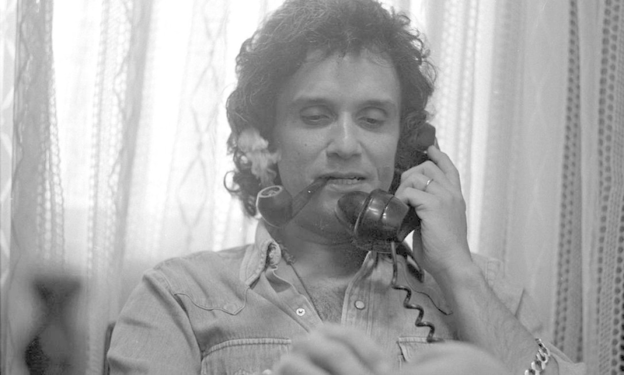 Roberto Carlos fuma cachimbo ao falar ao telefone Foto: Agência O Globo - 09/11/1976
